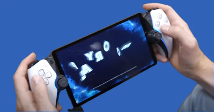 A man sitting in a chair, holding a playstation portal in his hands. He appears to be playing a video game